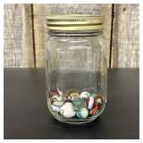 A Collection of Vintage Glass Marbles in a Glass M