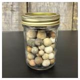 A Collection of Antique Clay Marbles in a Glass Ca
