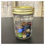 A Collection of Glass Marbles in a Glass Canning J