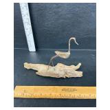 Copper bird on driftwood