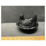 Black glass hen on the nest