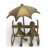 Brass Frogs On Bench Under Umbrella