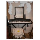 Keyboard, stool, and framed sheet music