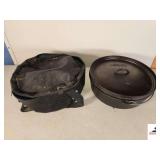 LODGE SEASONED DUTCH OVEN FOOTED - MARKED USA 14 CO - 14 INCH DIAMETER - 4 IN DEEP HAS LOOP HANDLE - COMES WITH CARRIER - (GARAGE)