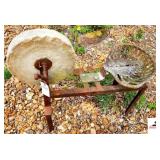 STONE GRINDING WHEEL WITH SHOP MADE STAND AND IRON IMPLEMENT SEAT - STONE WHEEL HAS CHIPE - (OUTSIDE)