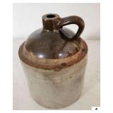 STONEWARE JUG W/ HANDLE - BROWN AND WHITE - CHIPS ON RIM - 9 1/2" BASE - 12" TALL - (KITCHEN)