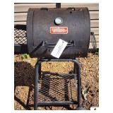 OUTDOOR GOURMET BARREL STYLE GRILL HAS ROLLERS ON ONE END - (OUTSIDE)
