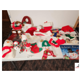 COLLECTION OF CHRISTMAS ITEMS- HATS, STOCKINGS, TOWELS, ANIMALS, BAGS, VINYL TABLECLOTHS- SNOWMAN CAROLERS- PORCELAIN HAND PAINTED FIGURINE-