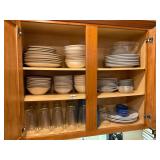 Large cabinet, full plates, mixing bowls, glasses.