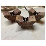 Three copper colored butterfly candleholders