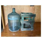 Glass 5 gallon water jug, and crate