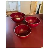 Set of three red round bottom bowls