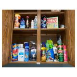Cabinet above dryer full of cleaning supplies