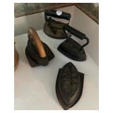 Four flat irons in trivet