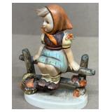 Hummel girl sitting on fence