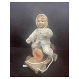 Boy sitting on log handmade figure