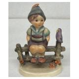 Hummel boy sitting on fence with bird