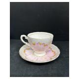 Pink flower, plant tea, cup, and saucer