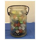 Vintage glass filled with marbles.  No lid