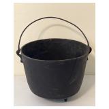 Antique cast-iron being pot has wire handle and