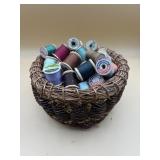 Vintage basket full of wooden thread spools