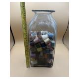 Vintage large glass jar full of wooden thread