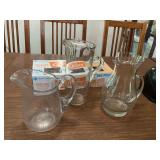 Three clear glass vases and assorted cutlery