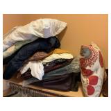 Shelf of bedding,  bags, and games