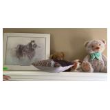 Contents of shelf above bed, bears, picture of horses, pillows
