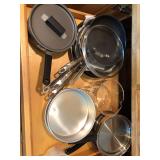 Cabinet of pots, pans, cake pan, and measuring cups