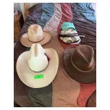 Group of hats, large cowboy hat, and visors