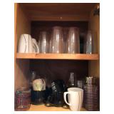 Two shelves of glasses and assorted mugs