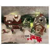 2 lighted houses with figures playing in the snow.