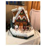 Electric ginger bread house that lights up and ice skater goes around and around and in and out of the house, vintage w/box