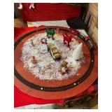 Miniature train that is battery operated with track attached to round plywood and various decorations included. Table it is on is not included