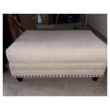 Cream Upholstered Ottoman with Nailhead Design