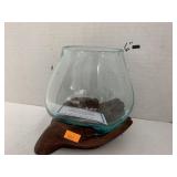 Glass bowl on driftwood hands, Indonesia