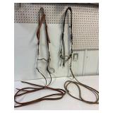 2 leather headstalls with bits. 1 set of reins