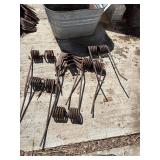 5 Harrow tines. 4 shovels in a tub.