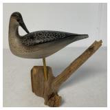 signed carved shorebird on driftwood