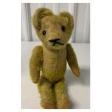 very worn glass eyed jointed teddy bear