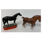 2 cast iron horses, one on a wooden base