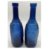 2 blue glass bottles with embossed drapery