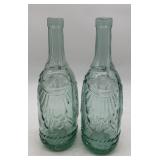 2 green glass bottles with embossed drapery