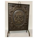 ornate fire screen with cherubs