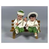 Painted Ceramic Figurines on Wooden Bench