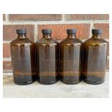 Four Amber Glass Bottles with Anchor Motif