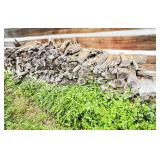 Stack of Cut Firewood Against Wooden Wall