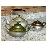 Three Metallic Teapots with Varying Finishes