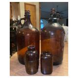 Grouping of (4) amber color jars…..(2) are apothecary and (2) are gallon jugs